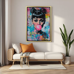 Golden-framed canvas of Audrey Hepburn blowing bubblegum, a blend of vintage charm and playful modern art for upscale interior wall decor