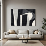 Modern black and beige abstract geometric canvas wall art displayed above sofa in minimalist living room