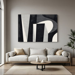 Modern black and beige abstract geometric canvas wall art displayed above sofa in minimalist living room