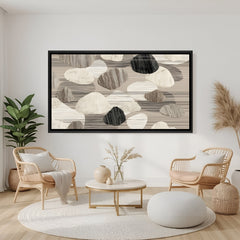 Neutral abstract pebble canvas wall art in beige and grey tones with black floater frame, styled above sofa in a contemporary minimalist living room