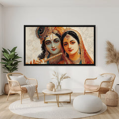 Luxury Radha Krishna panoramic artwork in black frame displayed above modern grey sofa.