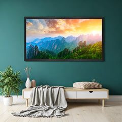 Sunrise painting with hills and rainbow-toned light spread due to curling sunrays, set in black floater frame for elegant and calming wall decor