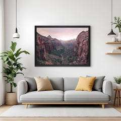 Canvas painting with red rock formations and small trees in a valley, presented in a black floater frame for dramatic and earthy wall art display
